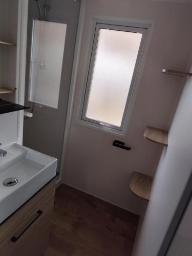 une salle de bain avec un lavabo et une fenêtre dans l'établissement KOKUA VACANCES Mobils Homes résidentiels camping 5 étoiles, à Saint-Georges-dʼOléron