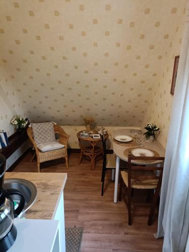 une cuisine et une salle à manger avec une table et des chaises dans l'établissement Maison d'hôtes Les Vallées, à Saint-Quentin-sur-le-Homme