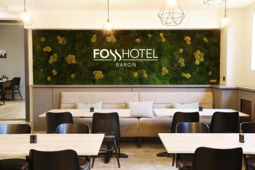 a restaurant with tables and chairs and a wall with flowers at Fosshotel Baron in Reykjavík