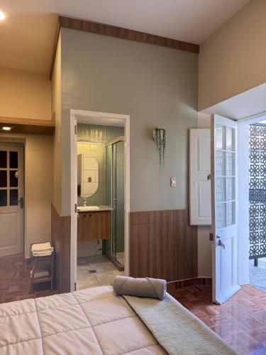 a bedroom with a bed and a bathroom with a sink at Habita Sucre in Sucre