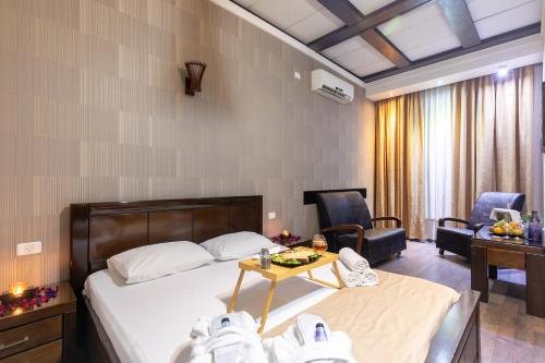 a hotel room with a bed and a table and chairs at Hotel House in Rishon LeẔiyyon