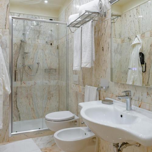 a bathroom with a sink and a toilet and a shower at La Paloma Blanca Hotel in Sciacca