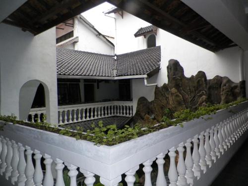 a building with a white fence and some plants at Bladok Hotel & Restaurant in Yogyakarta