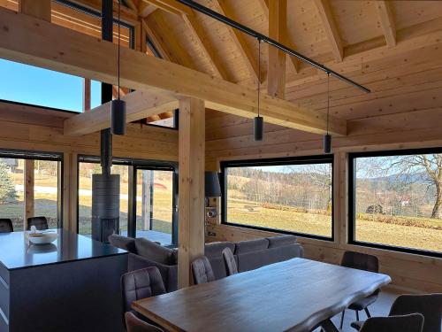 a dining room with a table and chairs and windows at Rezidence Cedrinum in Bublava