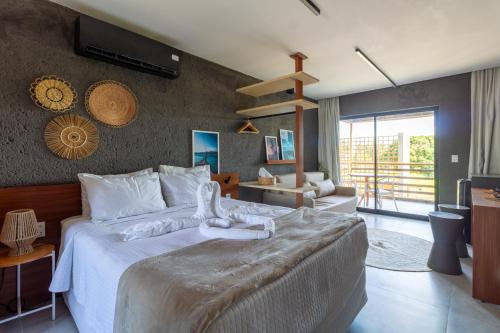 une chambre avec un grand lit et un salon dans l'établissement CONDOMINIO GAMBOA - 190 METROS DA PRAIA DO PATACHO, à Porto de Pedras