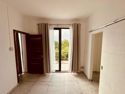 an empty room with an open door to a patio at Helios Haven in Flic-en-Flac