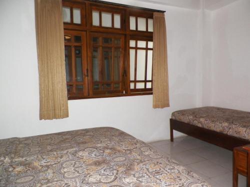 a bedroom with two beds and a window at Bladok Hotel & Restaurant in Yogyakarta