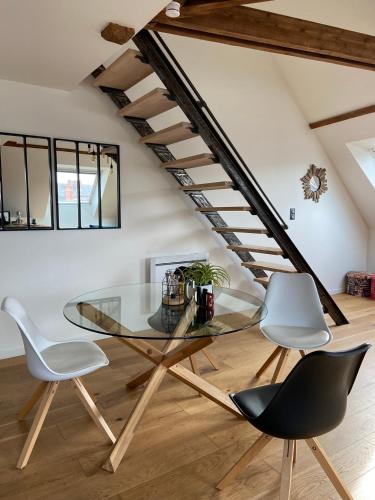 a dining room with a glass table and two chairs at "LE COCON" en HYPERCENTRE PARKING GRATUIT in Amiens