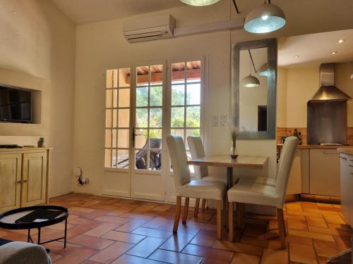 a kitchen and dining room with a table and chairs at Les Garrigues de la Vallée des Baux in Paradou