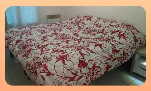 - un lit avec une couette rouge et blanche dans l'établissement Caraussane, à Sète