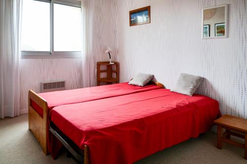 - une chambre avec un grand lit rouge dans l'établissement Maison de vacances avec grand jardin - la Chaume - 8 personnes, à Les Sables-dʼOlonne
