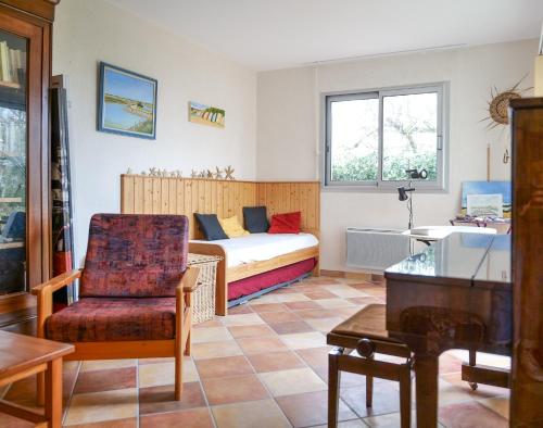 un salon avec un lit et une chaise dans l'établissement Maison de vacances avec grand jardin - la Chaume - 8 personnes, à Les Sables-dʼOlonne