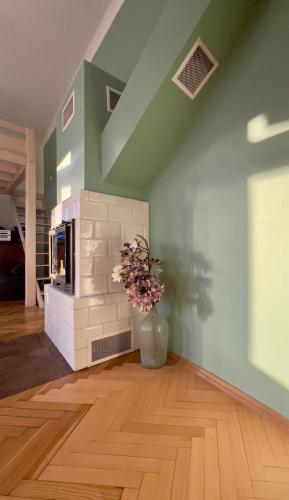 a living room with a fireplace and a vase with flowers at Apartament Ratuszowy in Cieszyn
