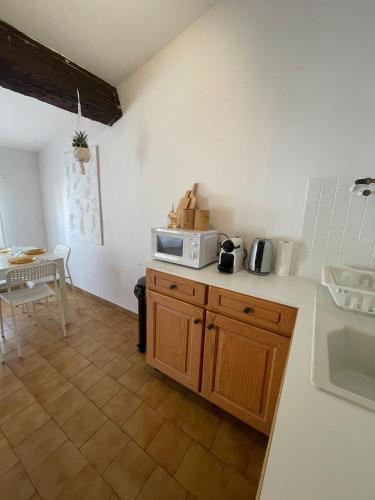 une cuisine avec un four micro-ondes au-dessus d'un comptoir dans l'établissement Escapade confort Toulon, à Toulon