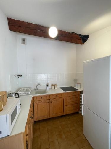 une cuisine avec un réfrigérateur blanc et un évier dans l'établissement Escapade confort Toulon, à Toulon
