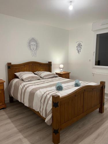 - une chambre avec un grand lit en bois et une télévision à écran plat dans l'établissement Escapade à la campagne, à Sottevast