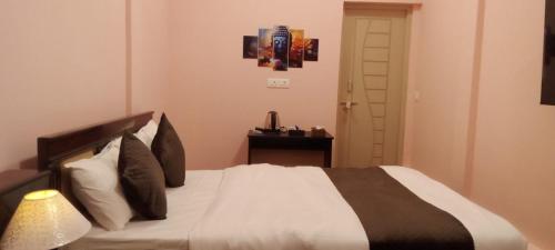 a bedroom with a bed and a table with a lamp at Chan Beach Resort & Hotel in Bahūr