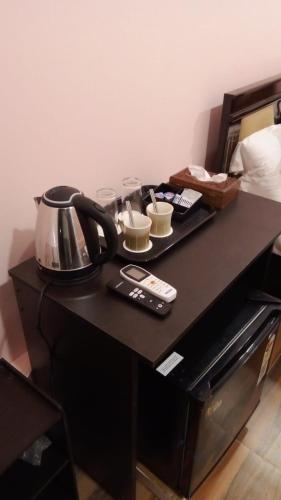 a table with a tea kettle and cups on it at Chan Beach Resort & Hotel in Bahūr
