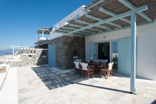 a patio with a table and chairs under a pergola at Sofia's Bungalows Mykonos in Mýkonos City