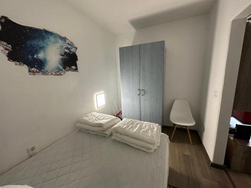 a white room with a bed and a cabinet at Moderne und komfortable Appartements im Ferienpark Hahnenklee in Hahnenklee-Bockswiese