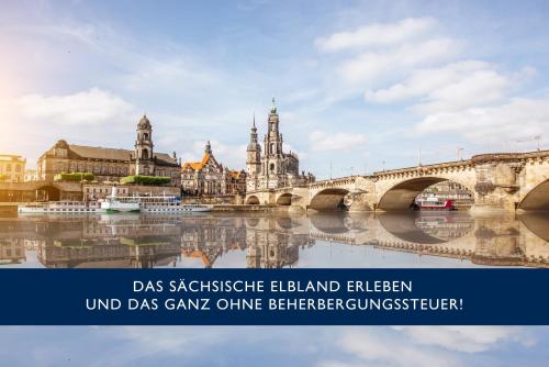 a bridge over a river in a city at City Hotel Dresden Radebeul in Radebeul