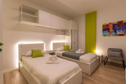 two beds in a room with green and white at Locami Bi-Apartments Padova in Padova