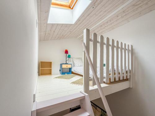 Cette chambre mansardée comprend un lit bébé et une lucarne. dans l'établissement Agreable maison de vacances - quartier arago - 6 personnes, à Les Sables-dʼOlonne