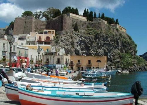 a group of boats docked in a harbor with a mountain at Via Roma 55 in Lipari