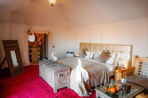a bedroom with a bed and a table with oranges on it at Riad Moha in Merzouga
