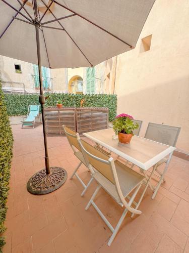 une table et des chaises avec un parasol sur une terrasse dans l'établissement Le Mattoni 3, à Menton