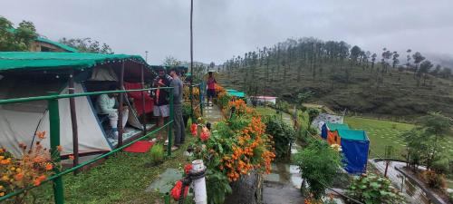 a group of people standing around a garden with flowers at Nisarg Camping Pods in Almora
