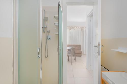 un bagno con doccia con porta in vetro di Cormorani - Appartamento 3 a Golfo Aranci