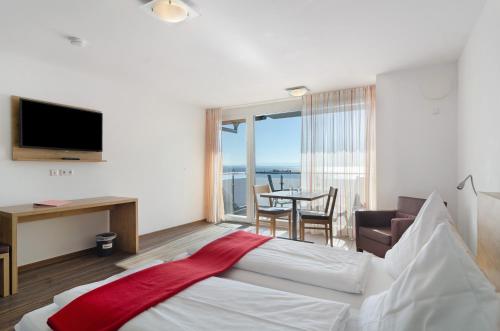 a hotel room with a bed and a view of the ocean at Gästehaus D i c k r e i t e r in Immenstaad am Bodensee
