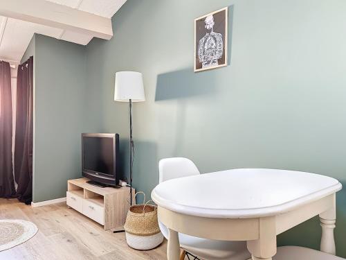 Il comprend un salon doté d'une table blanche et d'une télévision. dans l'établissement Studio centre historique, à Toulon