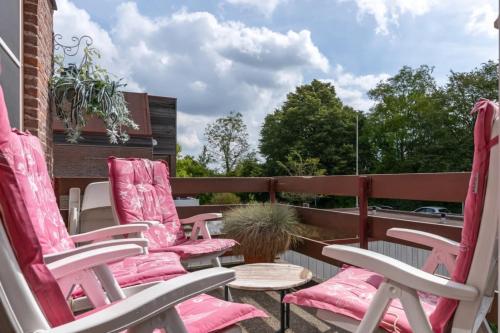 a row of pink chairs sitting on a patio at Hello Zeeland - vakantiewoning Buiten de Veste 36 in Veere