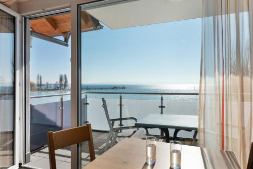 a balcony with a table and a view of the ocean at Gästehaus D i c k r e i t e r in Immenstaad am Bodensee