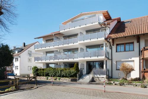 a white building with a balcony on a street at Gästehaus D i c k r e i t e r in Immenstaad am Bodensee