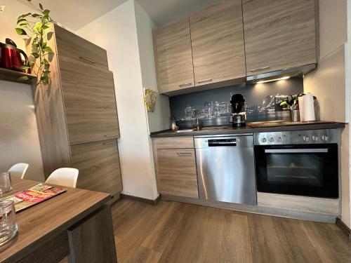 a kitchen with a stainless steel oven and wooden cabinets at Moderne und komfortable Appartements im Ferienpark Hahnenklee in Hahnenklee-Bockswiese