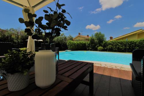 a vase on a wooden table next to a pool at Villa di Lago Albano - Castel Gandolfo in Albano Laziale