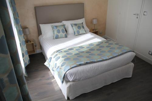 a bedroom with a large bed with blue pillows at Cosy Apparts Suresnes La Défense in Suresnes