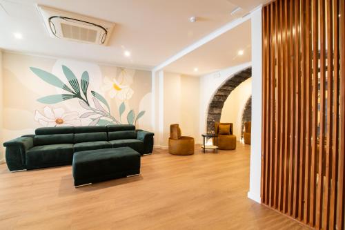a living room with a green couch and a wall at The Azoriani Boutique, Ascend Hotel Collection in Ponta Delgada