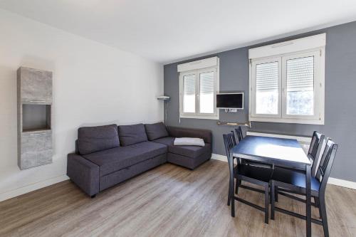 un salon avec un canapé et une table dans l'établissement Létanduère Wifi Tramway, à Angers