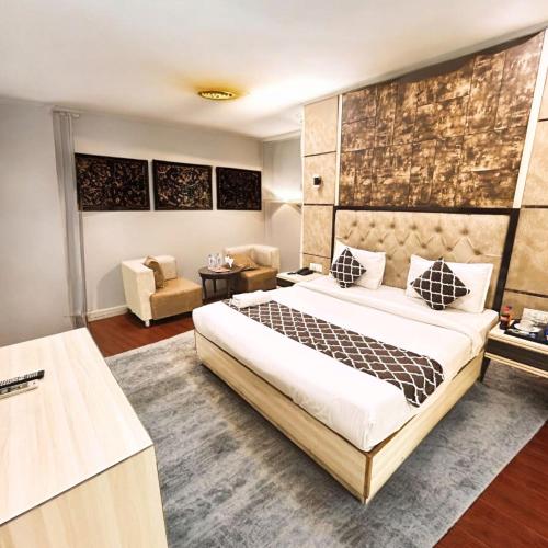 a bedroom with a large bed and a living room at Almora Hotel Delhi International Airport With - Free Airport Pickup in New Delhi