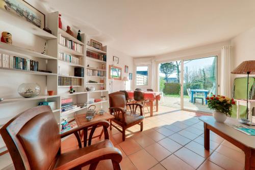 un salon avec une table et des chaises et une salle à manger dans l'établissement Maison pour 5 avec jardin a 300m de la plage, à Sarzeau
