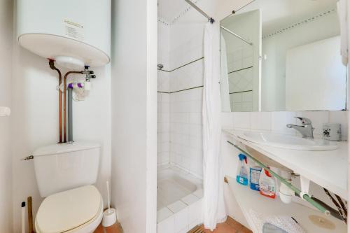 une salle de bain blanche avec des toilettes et un lavabo dans l'établissement Maison pour 5 avec jardin a 300m de la plage, à Sarzeau
