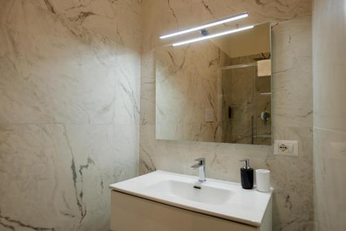 a white bathroom with a sink and a mirror at Relais Vittorio Veneto - Luxotel & Apartotel in Salerno