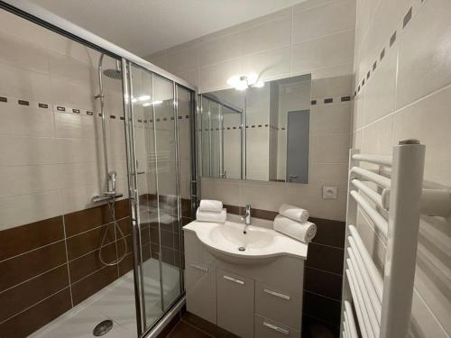 une salle de bain avec un lavabo et une douche en verre dans l'établissement Appartement 6 personnes Héliopolis - K 204, au Cap d'Agde