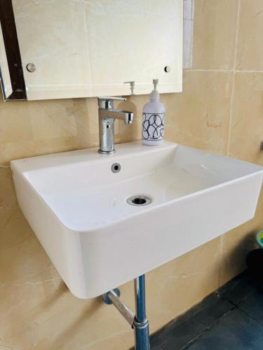 a white sink in a bathroom with a mirror at Feels Like Home in Ghaggar