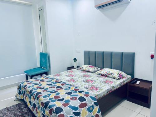 a bedroom with a bed and a blue chair at Feels Like Home in Ghaggar