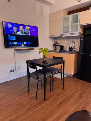 una cucina con tavolo e TV a parete di Condo in Mckinley Hill Taguig a Manila